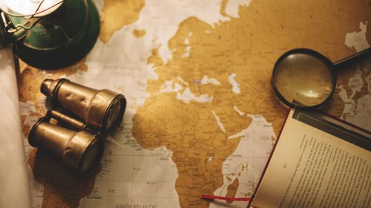 binoculars and magnifying glass on map